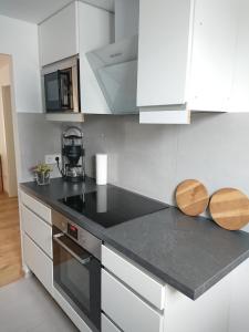 Una cocina con gabinetes blancos y una encimera negra. en Bungalow in Messenähe, en Hannover 3 fotos más