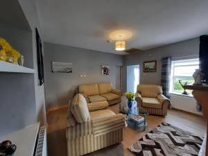 sala de estar con sofá y 2 sillas en Conneelys Cottage, Connemara, Clifden, H71Y096, en Clifden
