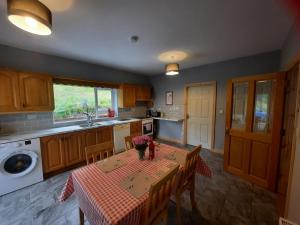 una cocina con mesa y mantel. en Conneelys Cottage, Connemara, Clifden, H71Y096, en Clifden