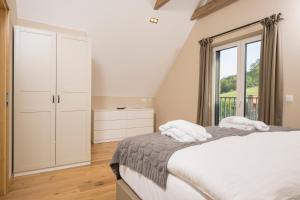 a bedroom with a bed and a window at WeinZeit Chalets in Gamlitz