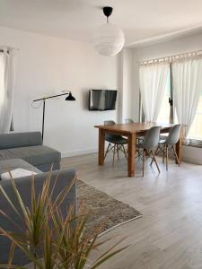 ein Wohnzimmer mit einem Holztisch und Stühlen in der Unterkunft Casa Alejandro 7 Las Vistas in Arona