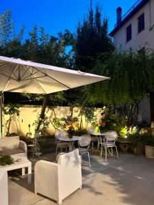 a patio with tables and chairs and an umbrella at Residenza Elisa in Desenzano del Garda
