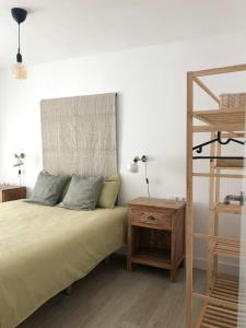 ein Schlafzimmer mit einem Bett und einem hölzernen Nachttisch in der Unterkunft Casa Alejandro 7 Las Vistas in Arona