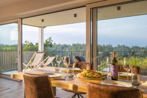 a table with wine glasses and a plate of food at WeinZeit Chalets in Gamlitz