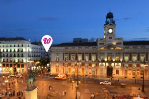 a large building with a clock tower on top of it at Woohoo Rooms Boutique Sol in Madrid