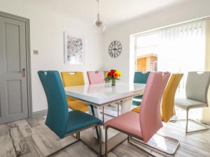 a dining room with a table and colorful chairs at Pelagos in Bude