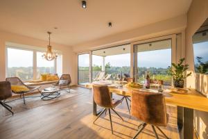 a dining room with a table and chairs and a living room at WeinZeit Chalets in Gamlitz