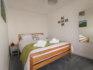 a bedroom with a bed with two towels on it at Pelagos in Bude