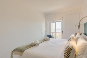 a bedroom with a bed with two towels on it at Belvedere TM Flat With a Magnificent View in Lisbon