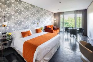 a hotel room with a bed and a desk and chairs at Apartosuites Jardines de Sabatini in Madrid +74 photos