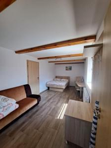 ein Wohnzimmer mit einem Sofa, einem Bett und einem Tisch in der Unterkunft Hybryda in Łeba