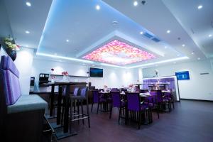 une salle à manger avec des tables et des chaises violettes dans l'établissement Hotel Cataleya, à Almere