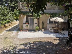 a building with a table and an umbrella at Ape Regina agriturismo 2 Montelarco in Rignano Flaminio