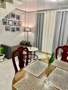 - un salon avec une table, des chaises et un canapé dans l'établissement NEW Modern Vacation Home Apartelle, à Iriga City