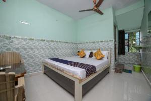 a bedroom with a bed and a ceiling fan at SPOT ON Hotel Ramgiri in Rāmtek