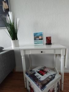 a white table with a plant on top of it at Apartment am Yachthafen in Kiel +27 photos