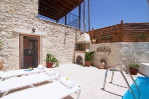 a patio with two lounge chairs and a fireplace at Villa Maris in Melissourgákion
