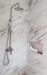 um chuveiro na casa de banho com azulejos de mármore branco em Mayara pool villas em Haad Yao