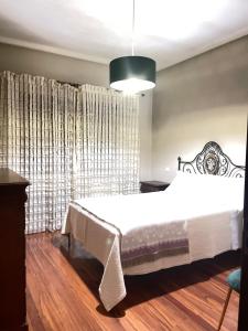 1 dormitorio con cama y ventana grande en CASA CAMPO DA FEIRA en Felgueiras