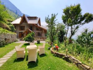 a house with white chairs in front of it at SaffronStays The Amlyn, Manali - unobstructed views of Beas river and the Himalayas in Manāli