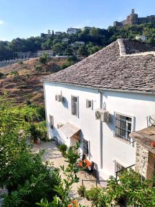 une maison blanche avec une colline en arrière-plan dans l'établissement Grandpa’s Home, à Gjirokastër