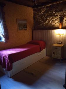 een slaapkamer met een bed met een rode deken bij La Era De Sanabria in Villarino de Sanabria