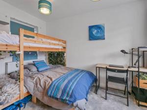 ein Schlafzimmer mit einem Etagenbett und einem Schreibtisch mit einem Schreibtisch in der Unterkunft Quiet Seaside Getaway with Hot Tub, Herne Bay in Greenhill