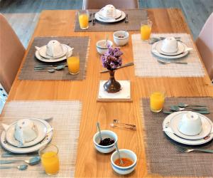 a wooden table with plates and bowls of food on it at Jardim das Oliveiras - Suítes com Vista in Ponte de Lima