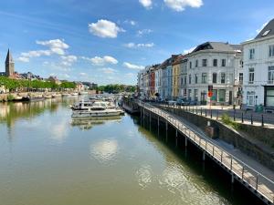 un río con barcos en una ciudad con edificios en Freetimeflat Mies & Fien, en Gante