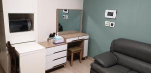 a room with a desk with a chair and a mirror at Gimcheon Gumi KTX Yulgokdong Apartment in Gimcheon
