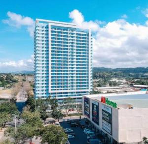 wysoki budynek z parkingiem przed nim w obiekcie Lifestyle at The Loop Towers Condotel w mieście Cagayan de Oro
