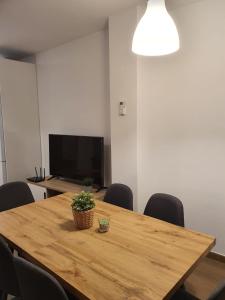 uma sala de conferências com uma mesa de madeira com cadeiras e uma televisão em Apartamento Trinidad Grund em Ardales