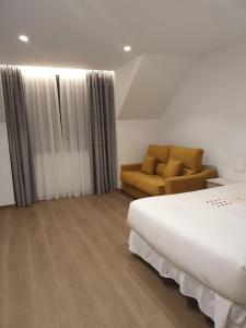 Habitación de hotel con cama y sofá en Apartamento Trinidad Grund en Ardales