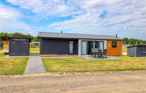una pequeña casa con un exterior naranja y negro en Lovely Home In Ssel With House A Panoramic View, en Süsel