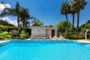 een zwembad met stoelen en een huis bij Villa Carra by Perle di Puglia in Parabita