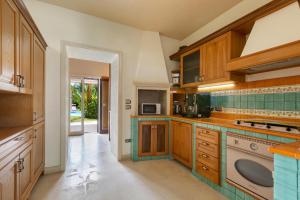een keuken met houten kasten en groene tegels bij Villa Carra by Perle di Puglia in Parabita
