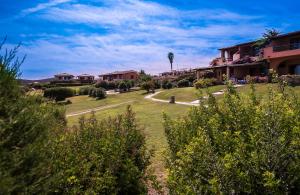 uma vista para um quintal com casas e árvores em Appartamenti Marineledda Golfo di Marinella em Golfo Aranci