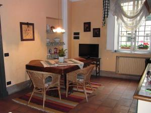 sala de estar con mesa de madera y sillas en Il Nido Di Tosca, en Lucca