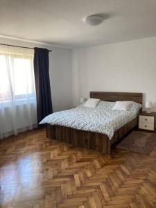1 dormitorio con 1 cama y suelo de madera en Casa Cheilor, en Petreştii de Jos