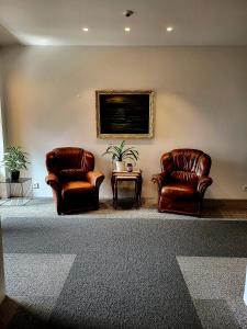 two leather chairs and a table in a room at Hótel Flókalundur in Brjánslækur