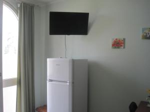 a white refrigerator with a flat screen tv on the wall at Tenuta Innocenzi in Sanarica