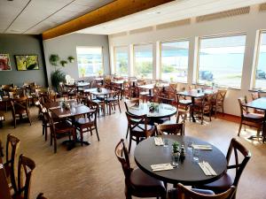 a dining room with tables and chairs and windows at Hótel Flókalundur in Brjánslækur