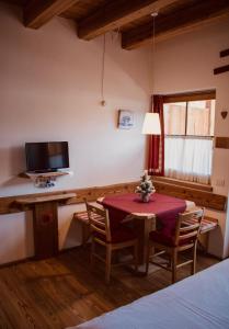 a dining room with a table and a tv at Residence Valpiccola in Val di Zoldo