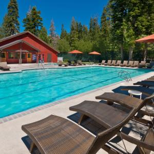a large swimming pool with chairs and a building at Granlibakken Tahoe in Tahoe City