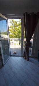 eine offene Glastür zu einem Balkon mit einer Terrasse in der Unterkunft Tower apartment in Sukošan