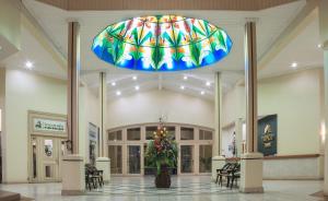 un'ampia hall con un grande lampadario in un centro commerciale di Hotel Tropico Inn a San Miguel