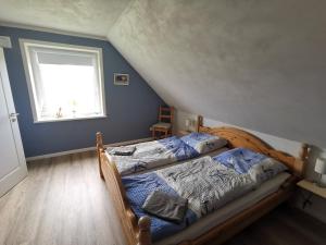 a bedroom with a bed and a window at Ferienwohnung SteifeBrise in Ockholm