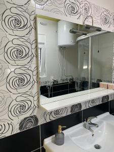 ein Badezimmer mit einem Spiegel und einem Waschbecken in der Unterkunft Villa Georgina in Vodice