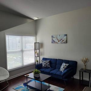 a living room with a blue couch and a table at Private 1 BDR with Free Parking, Just 5 Minutes from Downtown in Indianapolis