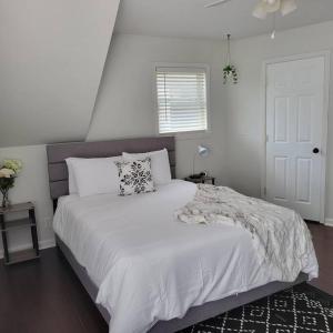 a white bedroom with a large bed with white sheets at Private 1 BDR with Free Parking, Just 5 Minutes from Downtown in Indianapolis